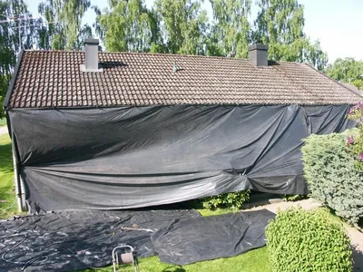 Före: villa med smutsigt, mossigt pannetak och fasaden täckt med skyddsduk