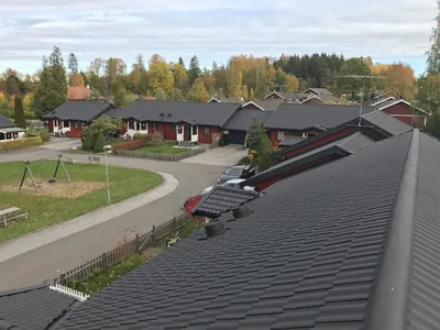 Efter: färdigbehandlat mörkt takfall från taknock med gården bakom, BRF Bergshöjden