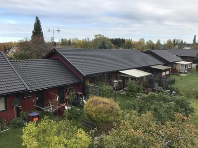 Efter: gårdsbild uppifrån med färdigbehandlade mörka tak hos BRF Bergshöjden i Gullspång