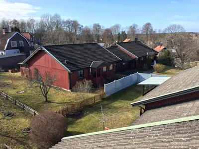 Före: rött parhus med gråa, slitna betongpannor sett från taknock hos BRF Bergshöjden