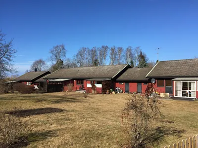Före: längor med röda hus och bleka, smutsiga tak i höstsol hos BRF Bergshöjden i Gullspång