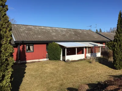 Före: rött enplanshus med mörkt tak och torr gräsmatta hos BRF Bergshöjden