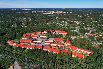 Efter: drönarbild över BRF. Ekvecklaren med röda tak i en skogsglänta i Huddinge