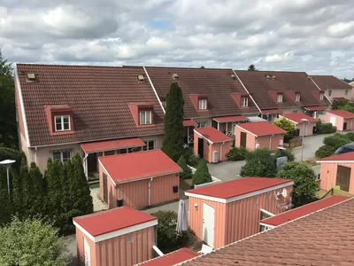 Före: rosa radhuslänga med kupor och mörkbruna, urblekta tak hos BRF. Ekvecklaren i Huddinge