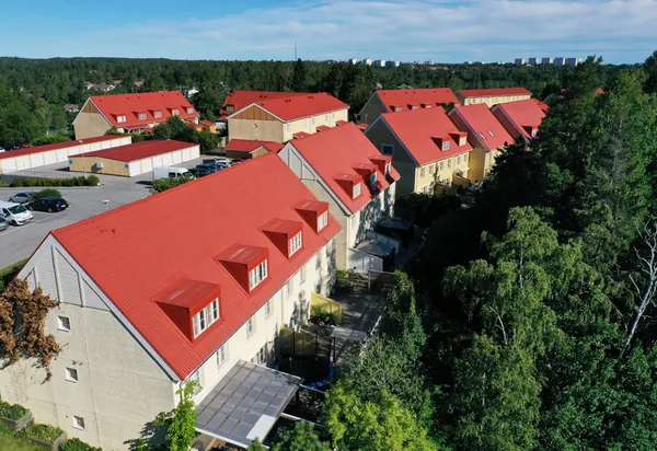 Drönarbild över flerbostadshus hos BRF. Ekvecklaren i Huddinge med färdigbehandlade röda tak och kupor