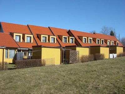 Efter: kedjehus med takkupor och nymålade röda tak hos BRF Fogdegården