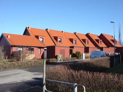 Efter: röda kedjehus hos BRF Fogdegården med färdigbehandlade tak, sedda från gatan