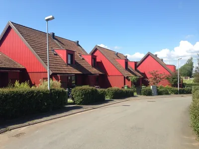 Före: röda kedjehus hos BRF Fogdegården med mörka, slitna tak, sedda från gatan