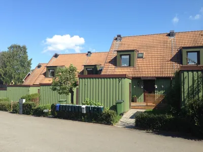Före: grönt kedjehus med takkupor och blekt tegeltak hos BRF Fogdegården