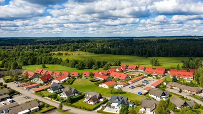Efter: drönarbild över BRF. Gamleby i Osby med färdigbehandlade röda tak och skog i bakgrunden