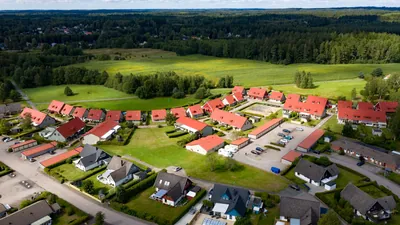 Efter: bostadsområdet hos BRF. Gamleby sett från sidan med nybehandlade röda tak i solsken