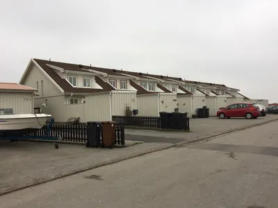 Före: gavel på BRF Gjutarens radhus med slitna betongpannor och parkerade bilar