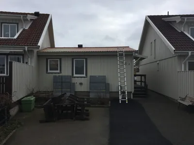 Före: baksida av radhus med stege mot tak och lägre takfall, BRF Gjutaren i Lysekil