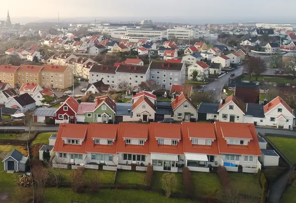 Drönarbild över radhuslänga med kvistar hos BRF Gjutaren i Lysekil med färdigbehandlade kopparbruna tak