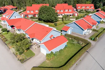 Efter: blå hus och garage med färdigbehandlade röda tak hos BRF. Gråsparven i Nora