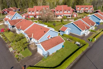 Före: blå trähus med garage och tak med blekt, ojämn färg hos BRF. Gråsparven i Nora