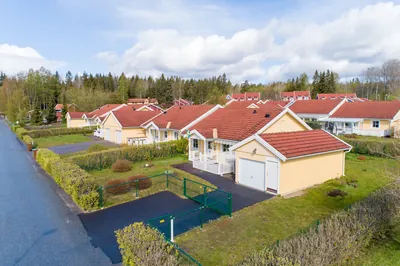 Före: gult hus med garage och matta tak vid gatan hos BRF. Gråsparven i Nora