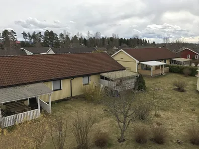 Före: längd av gula parhus med mörka, nedsmutsade tak och torra planteringar, BRF Hea i Sunne