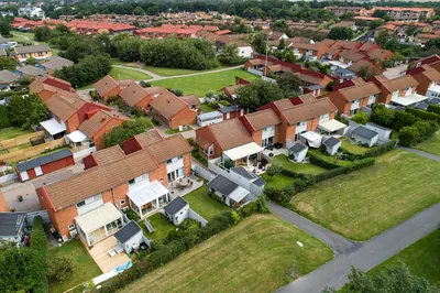 Före: tegelradhus med mörka, nedsmutsade betongpannor hos BRF. Helsingborgshus nr. 55 i Ödåkra