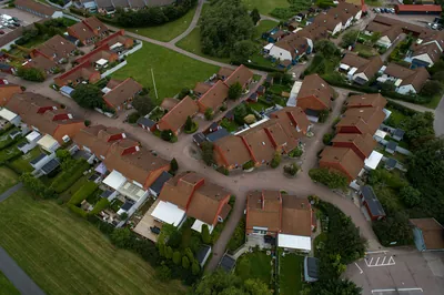 Före: kvarter med radhus och bruna, ojämnt blekta tak hos BRF. Helsingborgshus nr. 55, ovanifrån