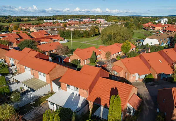 Drönarbild över tegelradhus hos BRF. Helsingborgshus nr. 55 i Ödåkra med nybehandlade, kopparbruna tak