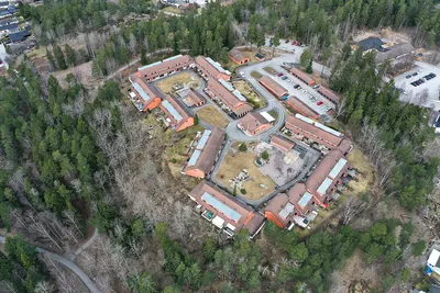 Före: drönarbild över BRF. Kaktusens radhuslängor i skogen