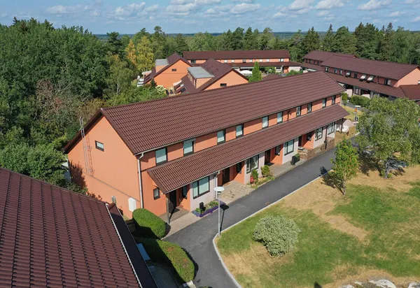 Radhuslängor hos BRF. Kaktusen i Södertälje med tak i mörkbrun kulör, fotat med drönare