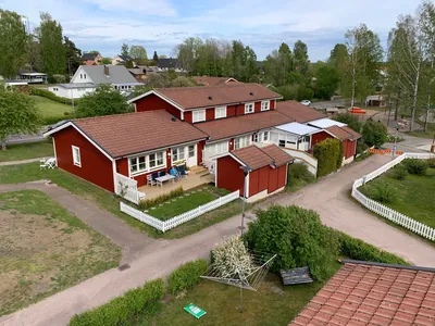 Före: rött trähus med brunt, nedsmutsat tak och vitt staket hos BRF. Karlstadshus nr 7 i Skattkärr