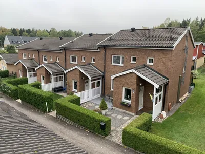 Före: radhus med häckar och bruna tak hos BRF. Knivstahus nr 4