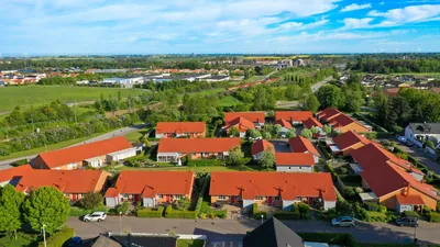 Efter: låga radhus med färdigbehandlade tegelröda tak och häckar hos BRF. Kommendanten