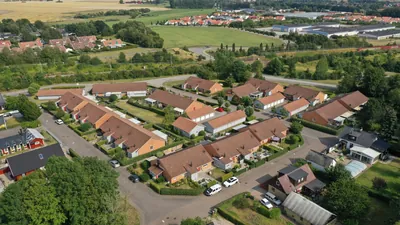 Före: enplansradhus med bruna, mörka tak hos BRF. Kommendanten i Kävlinge, drönarbild