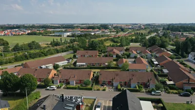 Före: radhuslängor med nedsmutsade, urblekta betongpannor hos BRF. Kommendanten, sett från sidan