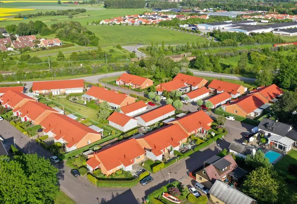 Drönarbild över lägre radhuslängor hos BRF. Kommendanten i Kävlinge med färdigbehandlade tegelröda tak