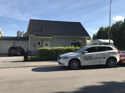Efter: grå radhusgavel med färdigbehandlat mörkt tak, från gatan hos BRF Mobacka