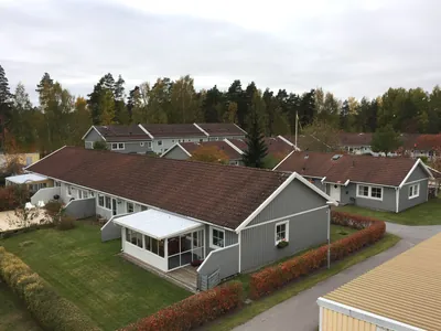 Före: långt radhus med inglasad uteplats och smutsigt rödbrunt tak hos BRF Mobacka