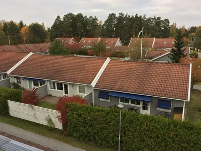 Före: radhusrad med matta, missfärgade takpannor sedd uppifrån hos BRF Mobacka