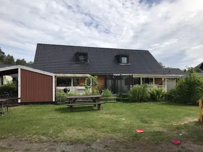 Efter: radhus med mörkt, jämnt tak och röd förrådsbyggnad hos BRF. Påskliljan i Västerås
