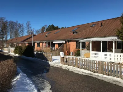 Före: tegelradhus med bruna, slitna tak och vit veranda i snö hos BRF. Påskliljan i Västerås