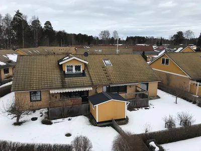 Före: radhus med gröngult tak täckt av mossa och alger hos BRF. Påskliljan, uppifrån