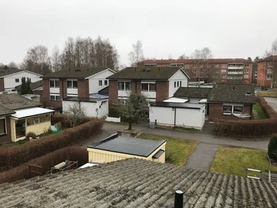 Före: radhus med gröna beläggningar på taken och ett gammalt tak i förgrunden, BRF. Rosen