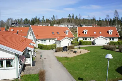 Efter: parhus med färdigbehandlat orangerött tak och lekplats hos BRF Rydet i Sandared