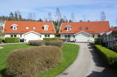Efter: två parhus med nymålat rött tak och garageinfart hos BRF Rydet