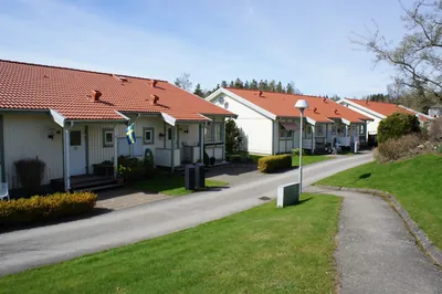 Efter: gångväg mellan parhus med rött färdigbehandlat tak hos BRF Rydet i Sandared