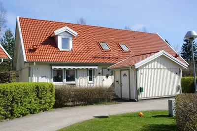 Efter: parhusgavel med takkupor och nybehandlat rött tak, nära hos BRF Rydet