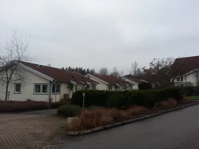 Före: vitt parhus med brunt tak med smuts, sett från vägen hos BRF Rydet
