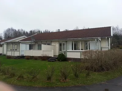 Före: långt parhus med inglasad veranda och mörkt matt tak hos BRF Rydet i Sandared