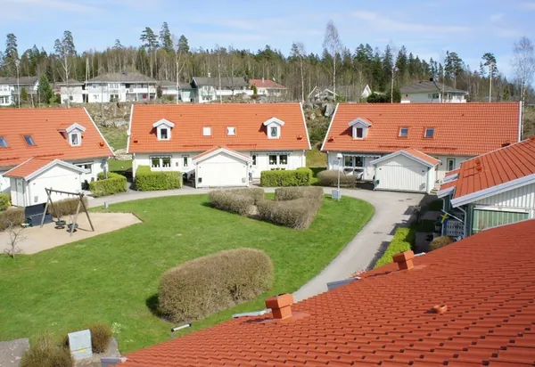 Parhus hos BRF Rydet i Sandared utanför Borås med nybehandlade orangeröda tak och lekplats