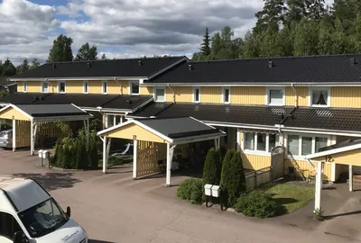 Efter: gula radhus med färdigbehandlat antracitgrått tak och carportar hos BRF. Sommarvinden