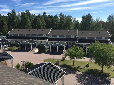 Före: radhuslänga med carportar och matt, smutsigt tak hos BRF. Sommarvinden i Kristinehamn
