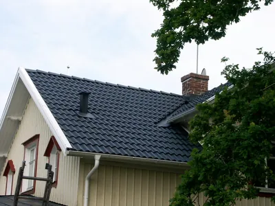 Efter: takfall och skorsten på villan med färdigbehandlade antracitpannor, sett från stege